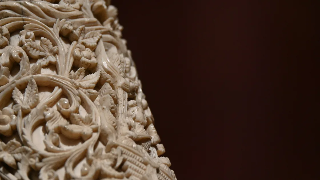 Detalle de una talla calada con motivos vegetales en relieve sobre material claro